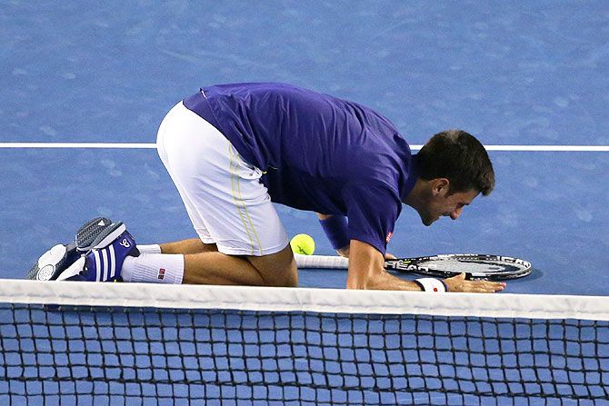 Novak Djokovic pats the Rod Laver Arena surface before kissing it after winning the final on Sunday