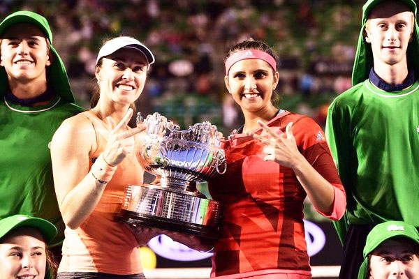 Sania Mirza and Martina Hingis celebrate with the trophy after winning the Australian Open women's doubles title on Friday