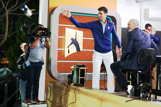 Novak Djokovic throws his shoes to the crowd during media interviews following his win over Andy Murray in the Australian Open final at Melbourne Park on Sunday