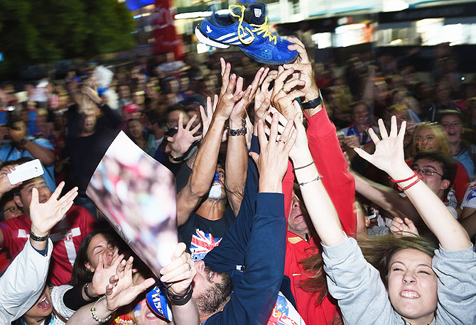 Serbian supporters wrestle for Novak Djokovic's shoe after he threw it into the crowd in garden square in Melbourne