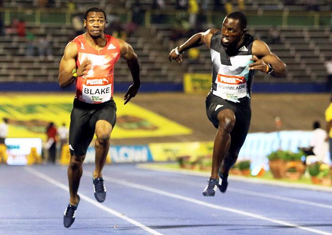 Yohan Blake (left) and Nickel Ashmeade in action during men's 100m final race at the Jamaica National Olympic trials in Kingston on Friday