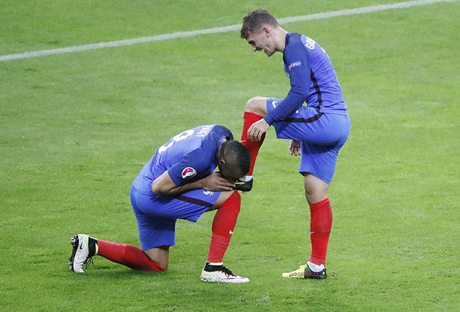 France's Dimitri Payet kisses the boot of Antoine Griezmann after the latter scored against Iceland in the quarter-final on July 3