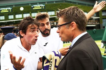 Pablo Cuevas (left) and Marcel Granollers of Spain argue with the match referee at Wimbledon on Monday