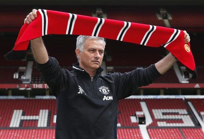 New Manchester United manager Jose Mourinho poses ahead of the press conference at Old Trafford