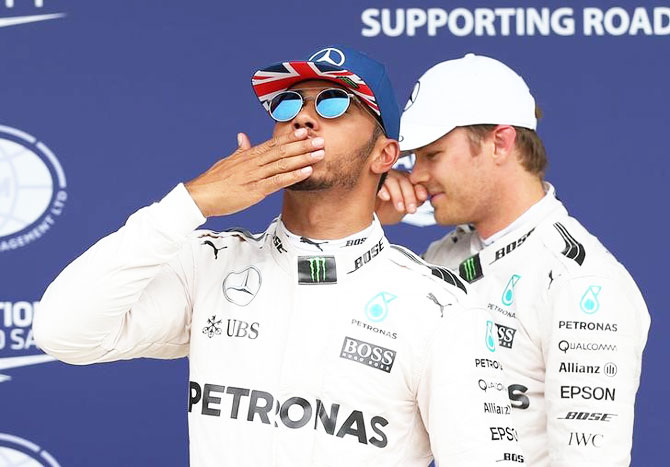 Mercedes' Lewis Hamilton celebrates qualifying in pole position with teammate Nico Rosberg who finished in second place at Silverstone on Saturday