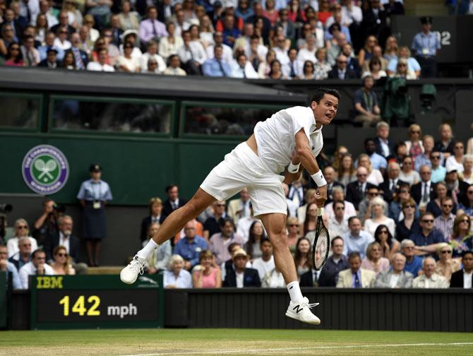 Milos Raonic serves during his match against Roger Federer