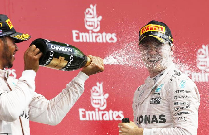 Mercedes' Lewis Hamilton celebrates on the podium with second placed Nico Rosberg
