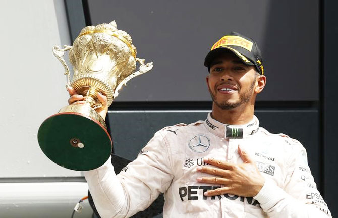 Mercedes' Lewis Hamilton celebrates on the podium with the trophy after winning the race at Silverstone 