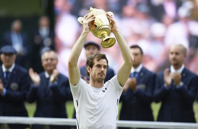 Britain's Andy Murray celebrates with trophy after defeating Canada's Milos Raonic to win the Wimbledon men's singles final on Sunday