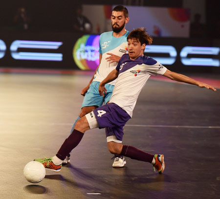 Kochi 5s Changuinha (Purple) in action with a Mumbai 5s (Blue) player during their Premier Futsal Football League match at Nehru Indoor Stadium in Chennai on Saturday