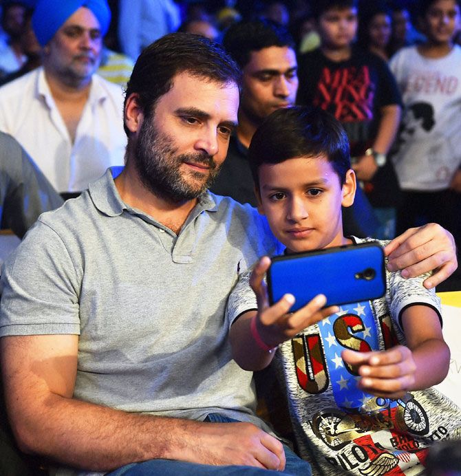 Congress vice-president Rahul Gandhi poses for a selfie with a 'fan' at the Thyagaraj stadium in New Delhi on Saturday before Vijender Singh's bout