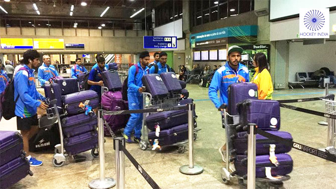 Indian hockey players make their way through the airport on arrival in Rio de Janeiro for the Olympic Games starting August 5