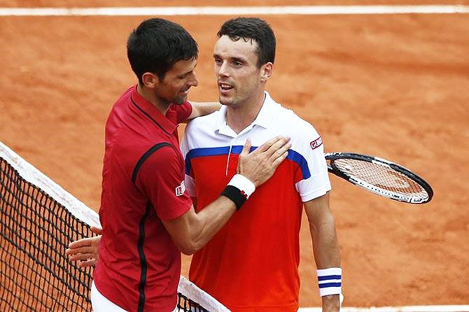 Novak Djokovic and Roberto Bautista Agut greet each other at the end after their match