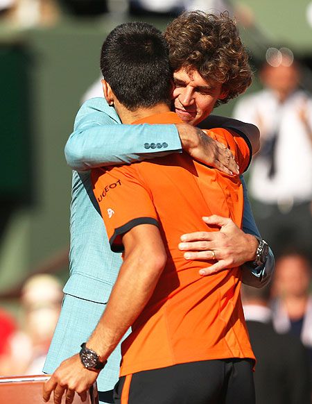 Gustavo Kuerten hugs Novak Djokovic