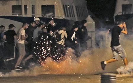 Police disperse revellers at the old port of Marseille after the England v Russia match on Saturday