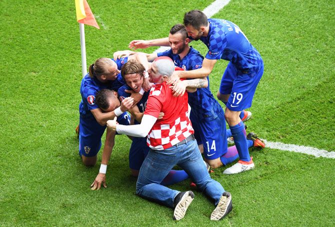 Croatia's Luka Modric (3rd from left) is mobbed by teammates and a fan as they celebrate scoring his team's first goal during the UEFA EURO 2016 Group D match against Turkey at Parc des Princes in Paris on Sunday