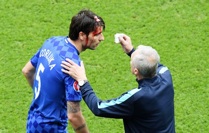 Croatia's Vedran Corluka receives medical treatment during the match.