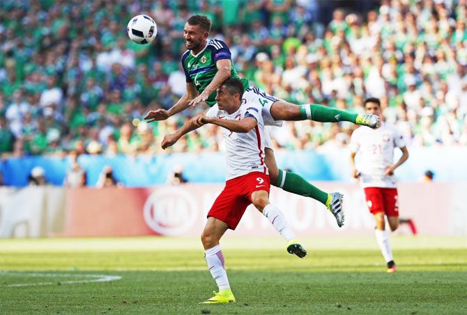 Poland's Robert Lewandowski (right) and Northern Ireland's Gareth McAuley are involved in an aerial challenge as they vie for possession during their Group C match in Nice on Sunday, June 12.