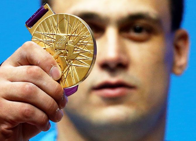 Kazakhstan's Ilya Ilyin poses with his gold medal of the men's 94Kg weightlifting competition at the ExCel venue at the London 2012 Olympic Games August 4, 2012