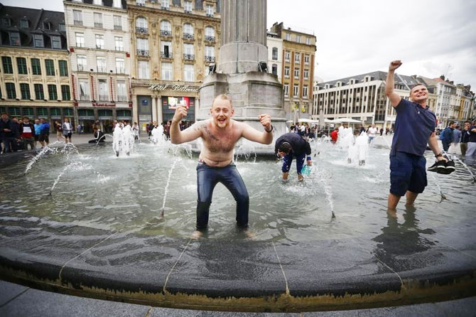 England fans celebrate their team's Euro 2016 Group B match win over Wales in a fountain in Lille on Thursday