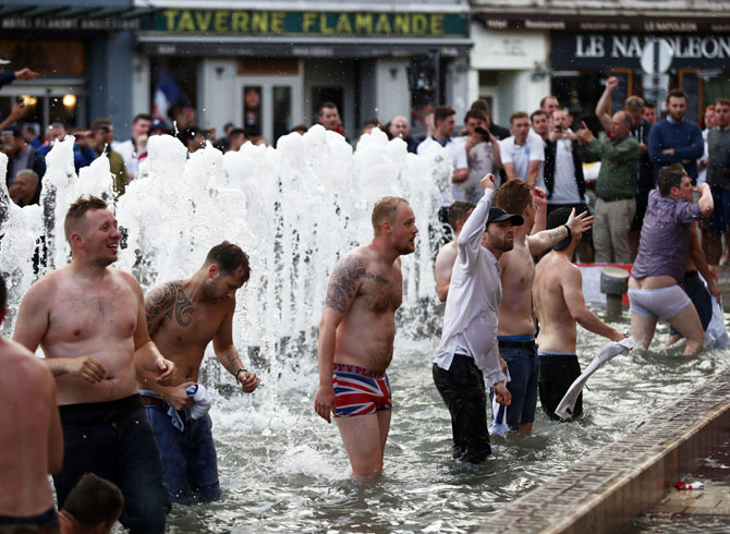England fans chant songs and play in a fountain in Lille