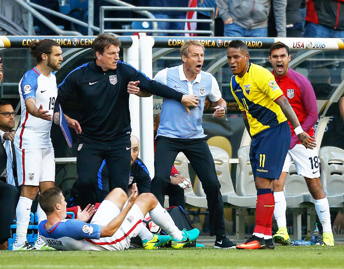 USA's head coach Jurgen Klinsmann reacts after Ecuador's Michael Arroyo #11 of knocked down USA's Matt Besler (right)