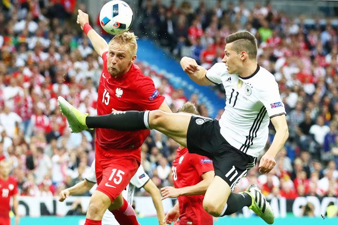 Germany's Toni Kroos (right) battles for the ball with Poland's Kamil Glik