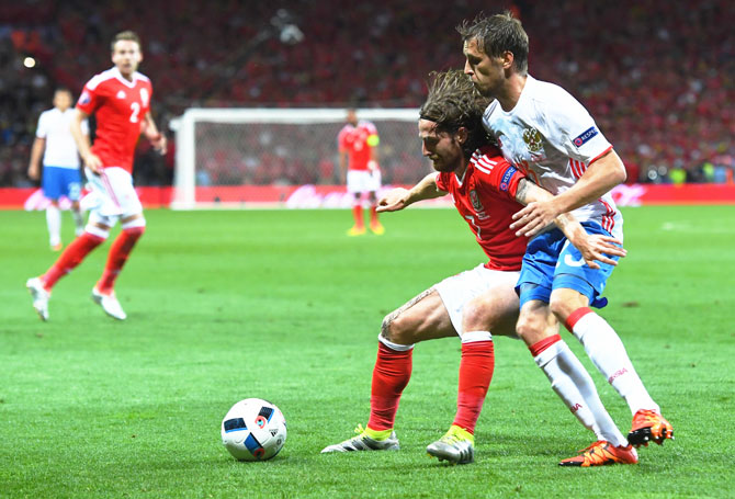 Wales' Joe Allen controls the ball under pressure from Russia's Dmitri Kombarov