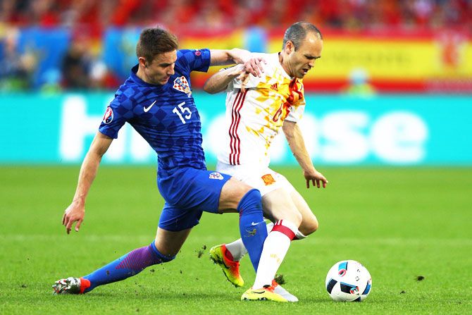 Spain's Andres Iniesta is challenged by Croatia's Marko Rog