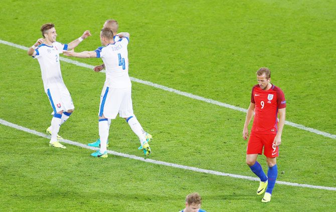 England's Harry Kane (right) leaves the pitch while Slovakia players celebrate after drawing the match