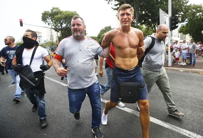 A Poland fan is detained by police in Marseille, France on Tuesday