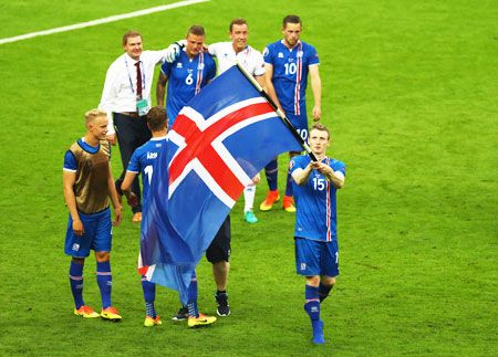 Iceland's Jon Dadi Bodvarsson leads celebrations with his national flag after victory over Austria in the Euro 2016 Group F match at Stade de France in Paris on Wednesday