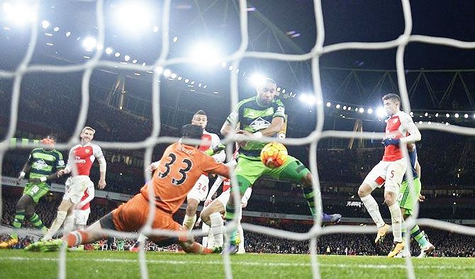 Swansea's Ashley Williams scores past Arsenal 'keeper Petr Cech for the second goal at the Emirates Stadium in London