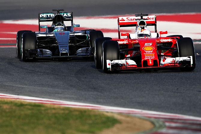 Ferrari's German driver Sebastian Vettel drives ahead of compatriot, Mercedes GP's Nico Rosberg during the F1 winter testing at Circuit de Catalunya in Montmelo, Spain