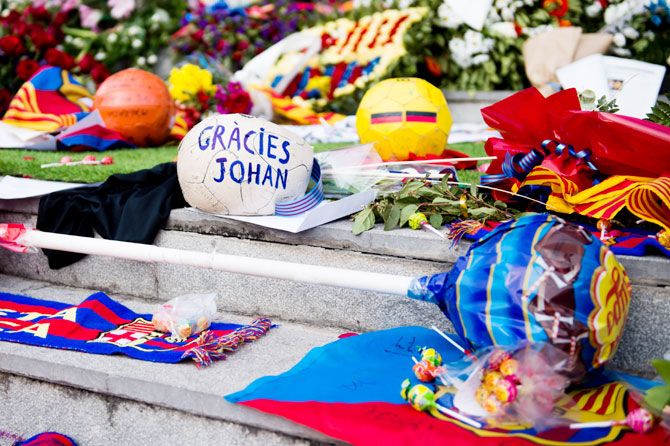 A ragged football with a message saying 'Thanks Johan' in Catalan is left by football fans is seen amongst gifts and flowers as a tribute to late Dutch football star Johan Cruyff at a memorial service on Tuesday