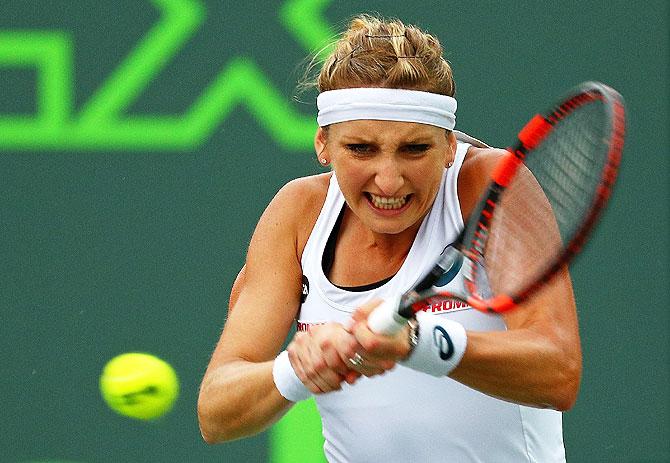 Timea Bacsinszky plays a backhand against Simona Halep