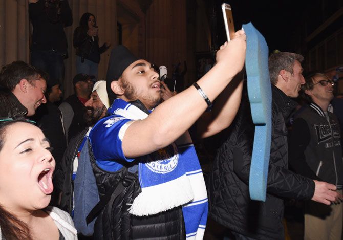 Leicester City fans celebrate as their team becomes Premier League champions