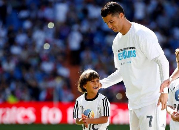 Zaid, son of Osama Abdul Mohsen, smiles as he stands next to Real Madrid's Cristiano Ronaldo before the Spanish first division soccer match against Granada at Santiago Bernabeu stadium in Madrid, on September 20, 2015