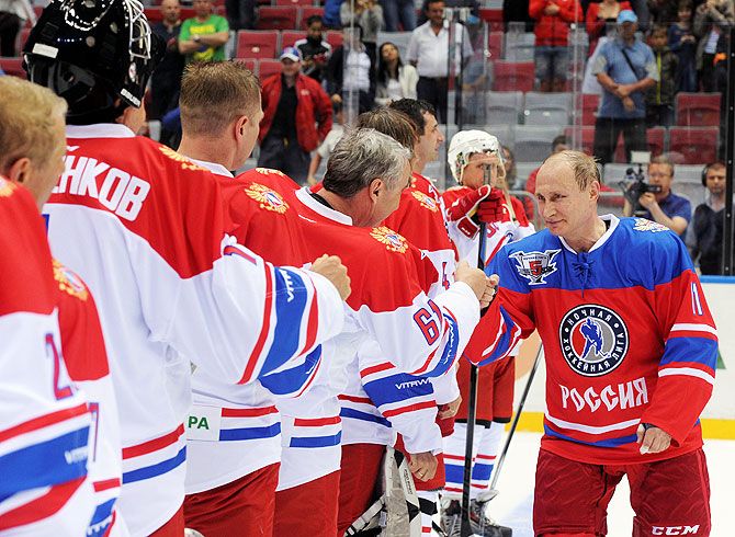 Russian President Vladimir Putin greets participants of a gala game of the Night Ice Hockey League