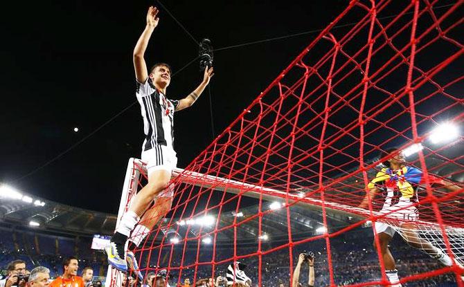 Juventus' Paulo Dybala and teammate Juan Cuadrado celebrate at the end of the match against AC Milan