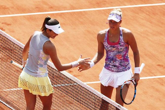 Garbine Muguruza greets Yanina Wickmayer at the net after the win