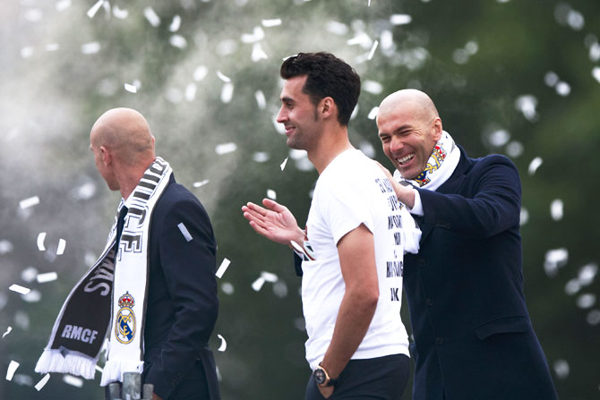 Head coach Zinedine Zidane (right) jokes with Alvaro Arbeloa (2nd from right) during their team celebrations at Cibeles Square