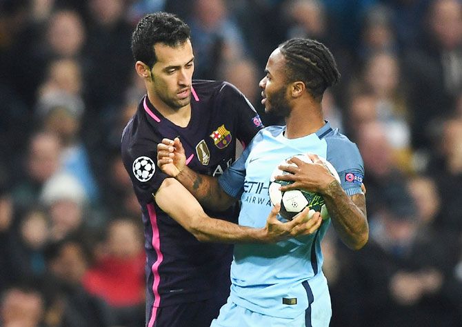 Manchester City's Raheem Sterling and Barcelona's Sergio Busquets clash