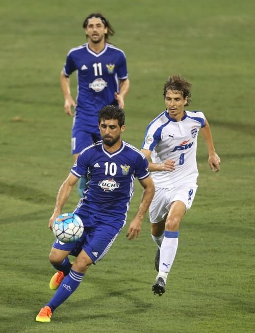 Air Force Club's Hammadi Ahmed (left) runs past a Bengaluru FC player during the AFC Cup final in Doha on Saturday