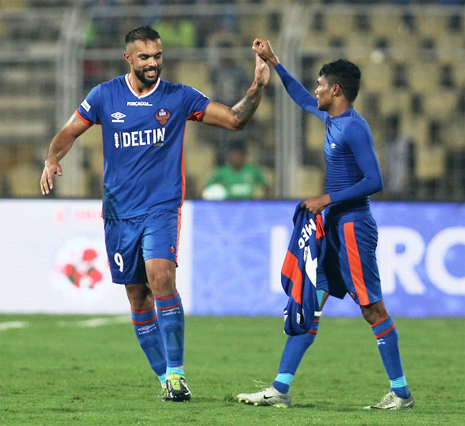 FC Goa's Robin Singh and Romeo Fernandes celebrate the winner against North East United FC in Goa on Friday