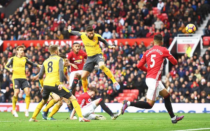Arsenal's Olivier Giroud (centre) heads to score the equaliser during their English Premier League match against Manchester United at Old Trafford in Manchester on Saturday
