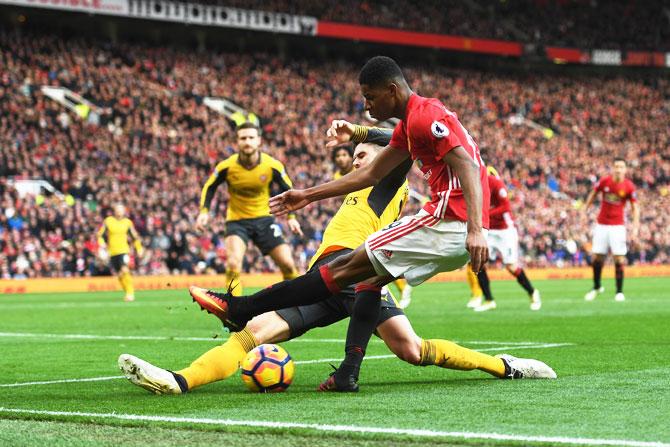 Arsenal's Carl Jenkinson (left) challenges Manchester United's Marcus Rashford (right)