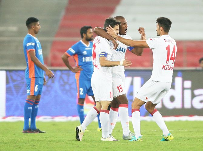 Players of Delhi Dynamos celebrate the hattrick by teammate Marcelo Pereira during their ISL match against FC Goa on Sunday