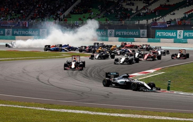  Mercedes' Lewis Hamilton of Britain leads as Mercedes' Nico Rosberg of Germany skids to the back during the first lap of the Malaysian GP