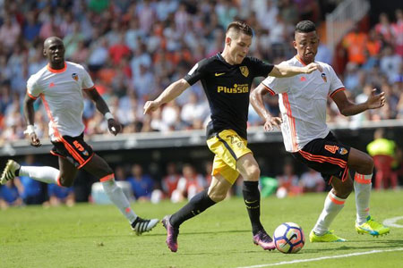 Atletico Madrid's Kevin Gameiro and Valencia's Aderlan Santos vie for possession